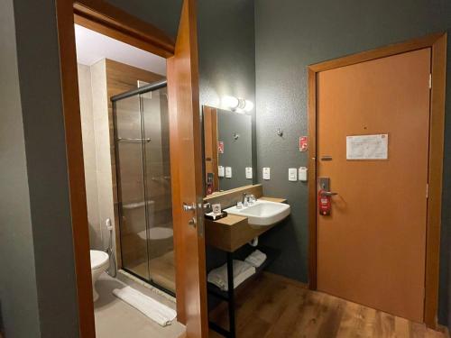 a bathroom with a sink and a shower and a toilet at Hotel 10 Joinville in Joinville