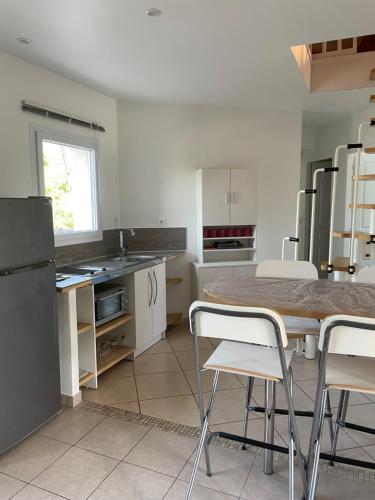 une cuisine avec une table et des chaises dans l'établissement Chez Peggy & Victor - Appartement 4/5 personnes, à Nâves-Parmelan
