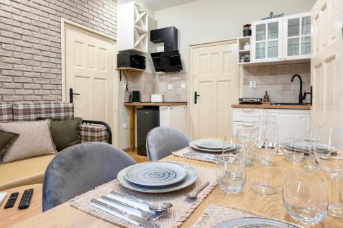 a dining room with a table with plates and wine glasses at ApartPro Apartments, Veliko Tarnovo in Veliko Tŭrnovo