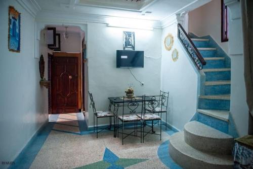 a hallway with stairs and a table with a television at Chez laasri in Chefchaouene