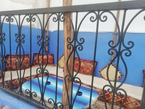 a iron fence with a bed in a room at Chez laasri in Chefchaouene