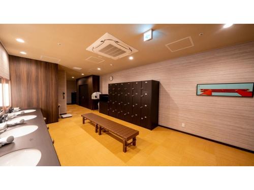 un baño público con un banco en una habitación en La'gent Stay Hakodate Ekimae - Vacation STAY 88785v, en Hakodate