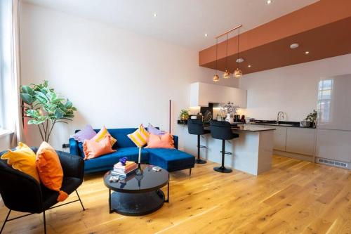 uma sala de estar com um sofá azul e uma cozinha em Dusk House - Wyndale Living - B'ham JQ Townhouse em Birmingham
