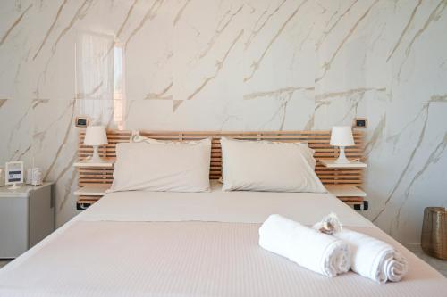 a bedroom with a bed with white sheets and pillows at Il Porticciolo in Scilla