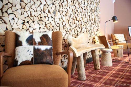 a room with chairs and a wall of logs at Hôtel Le Refuge des Sources in Digne-les-Bains