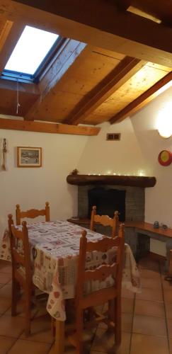 a dining room with a table and a fireplace at Casetta con camino in La Magdeleine