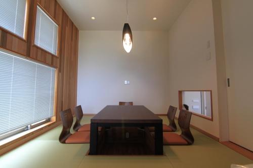 a dining room with a table and chairs and a mirror at MAISON DE AILE - Vacation STAY 58600v in Amami