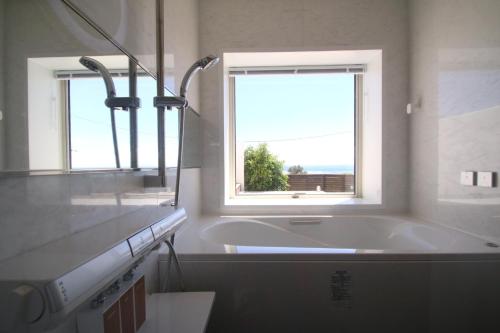 baño con bañera y ventana en MAISON DE AILE - Vacation STAY 58600v, en Amami