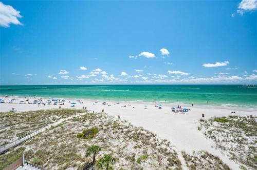 a beach with a lot of people and the ocean at Oceanfront View of Madeira Beach, Steps to the Beach - Madeira Norte Condo in St Pete Beach