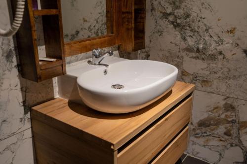 lavabo blanco en una encimera de madera en el baño en İstanbuldere Alabalıkevi, en Sapanca