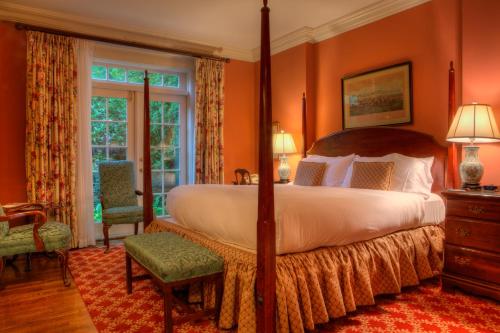 a bedroom with a large bed with orange walls at Francis Malbone House in Newport
