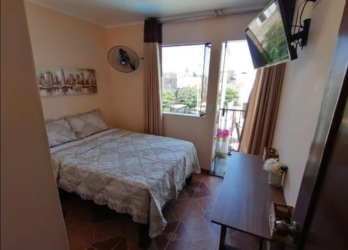 1 dormitorio con cama y ventana grande en Hotel San Isidro, en Pisco