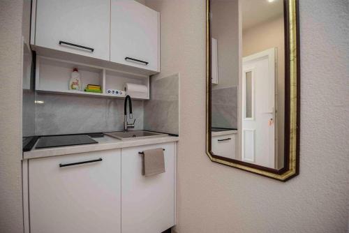 a kitchen with a mirror and a sink and a counter at Apartmani Berdovic in Trebinje