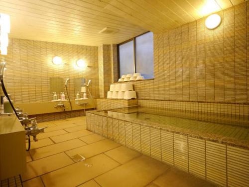 Hotel Fukui Castle - Vacation STAY 58682v في فوكوي: حمام كبير مع مغسلتين وحوض استحمام