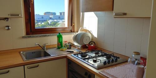 a kitchen with a sink and a stove and a window at Villa4Holydays - M1 subway in Milan
