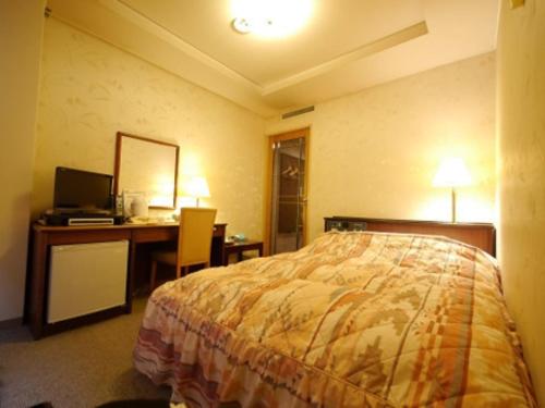 Cette chambre comprend un lit et un bureau avec un ordinateur. dans l'établissement Hotel Fukui Castle - Vacation STAY 58705v, à Fukui