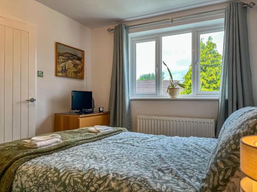 a bedroom with a bed and a window at Pennies Retreat in Glossop