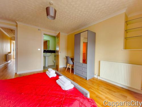 a bedroom with a red bed with white pillows at Bridge Street Guest Rooms in Tranent