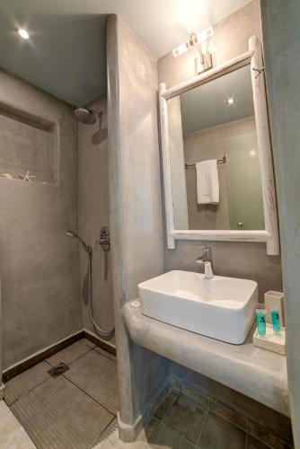 a bathroom with a sink and a shower and a mirror at Ifestos Villa in Fira