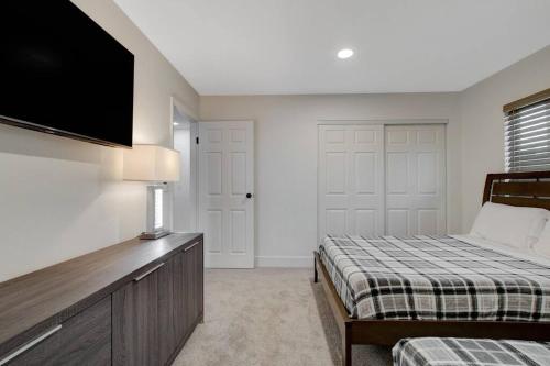 1 dormitorio con 2 camas y TV de pantalla plana en Vegas Hideaway~Pool, Bar, Many beds~NEAR STRIP, en Las Vegas