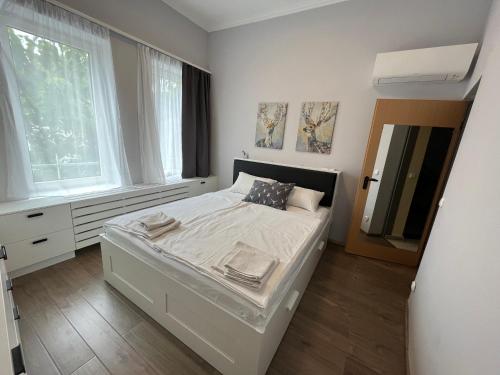 una camera bianca con un letto e due finestre di már vártaLAK a Fő téren a Siófok