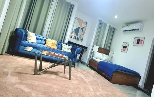 a living room with a blue couch and a chair at The FJORD at Martsmith in Accra