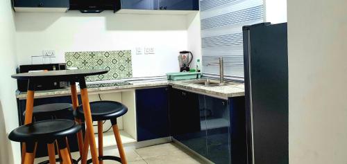 a small kitchen with a counter and stools in it at The FJORD at Martsmith in Accra