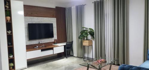 a living room with a desk with a tv on a wall at The FJORD at Martsmith in Accra