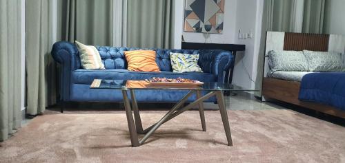 a living room with a blue couch and a table at The FJORD at Martsmith in Accra