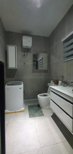 a bathroom with a toilet and a sink at The FJORD at Martsmith in Accra