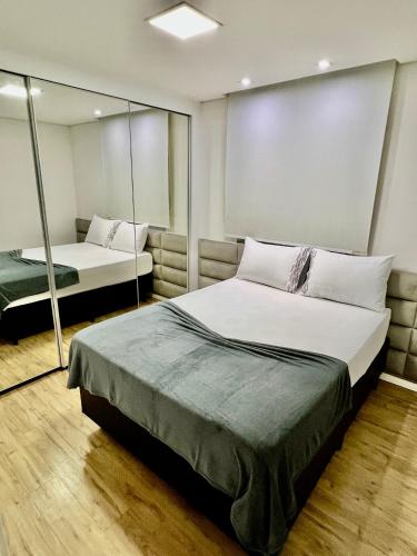 a bedroom with two beds and a mirror at Conforto Expo Center Norte in São Paulo