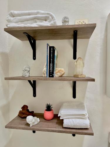 a bathroom shelf with towels and a book at The stones house in the Historic Downtown in Querétaro