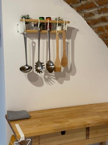 a shelf with spoons hanging on a wall at Pensiunea Oacheș in Sălaşu de Sus