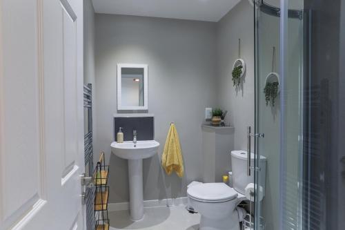 La salle de bains est pourvue de toilettes, d'un lavabo et d'une douche. dans l'établissement Modern Craigie Apartment, à Perth