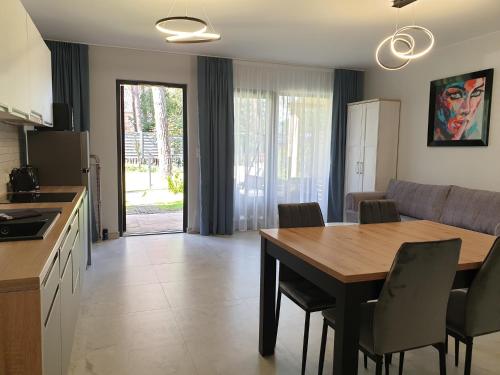 a kitchen and dining room with a table and chairs at Apartamenty Kornel 3 in Pobierowo