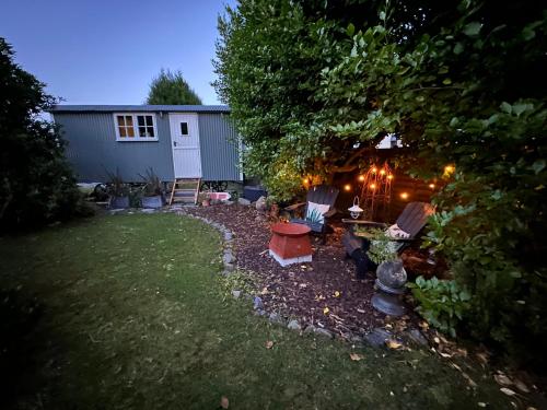 a backyard at night with chairs and a table at Miners Hut in St Austell