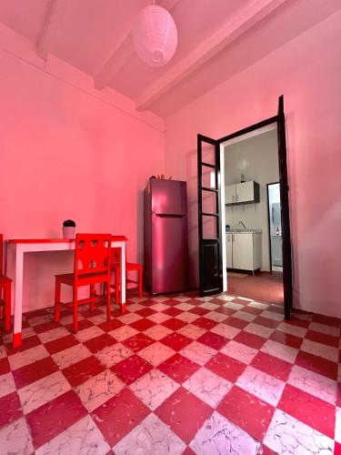 a pink room with a table and a refrigerator at The stones house in the Historic Downtown in Querétaro