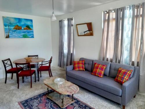 ein Wohnzimmer mit einem Sofa und einem Tisch in der Unterkunft Dado's Place in Calibishie