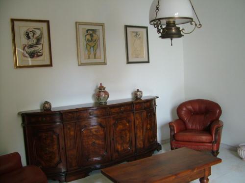 a living room with a wooden cabinet and a chair at B&B Maison Rosetta IUN-E4948 in Nuoro