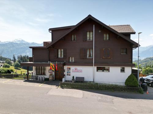 a large wooden building with a sign in front of it at Hotel Fassbind Beausite in Beatenberg