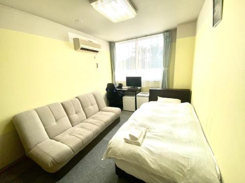 ein Hotelzimmer mit einem Sofa und einem Bett in der Unterkunft HDK Hotel - Vacation STAY 07718v in Tsu