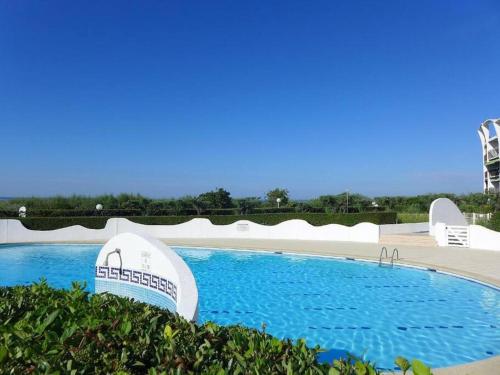 una gran piscina de agua azul en un complejo en VUE MER 50 m plage du couchant 1er ligne Piscine Parking, en La Grande-Motte