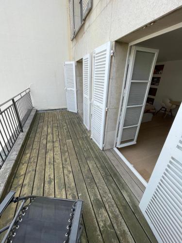 una terrazza in legno con porta e balcone di Superbe studio avec balcon, situé entre 6è et 7è ! a Parigi