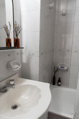 a white bathroom with a sink and a shower at Tu Hogar en Trelew I Calidez y practicidad in Trelew