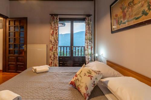 a bedroom with a large bed with a window at Thalia's Abode in Agios Lavredios