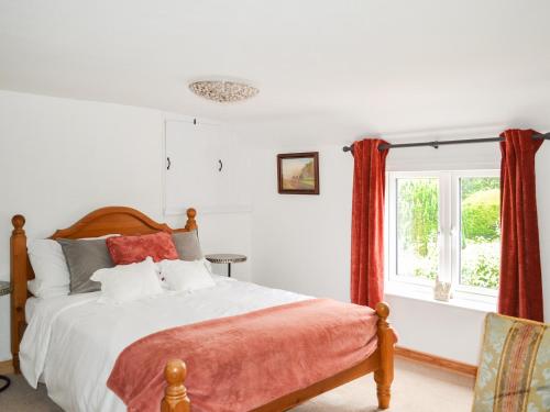 a bedroom with a bed and a window at Victory Hall Cottage in Spilsby