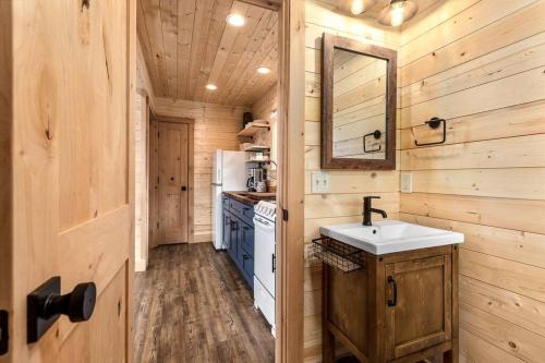 a kitchen with wooden walls and a sink and a mirror at Thunderbird Ridge - Cabin 1 - Summit in Polebridge