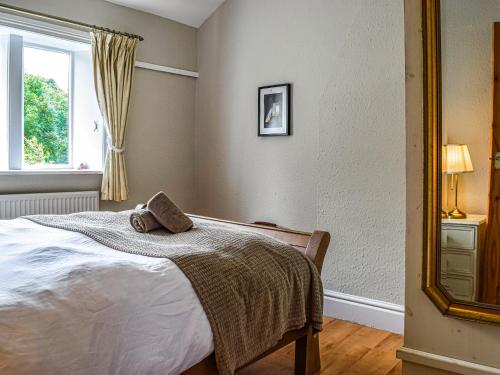a bedroom with a bed and a window and a mirror at Lavender Cottage in Kirkburton