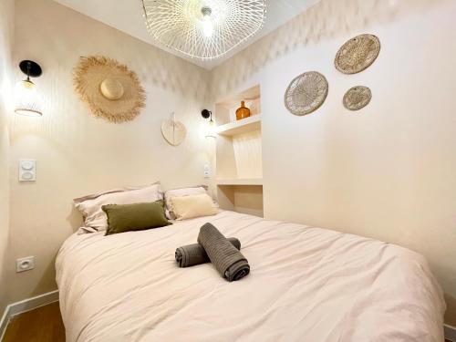 ein Schlafzimmer mit einem großen weißen Bett mit Kissen darauf in der Unterkunft Cosy & Chill Appartements - Au cœur du village de Cotignac, en Provence in Cotignac