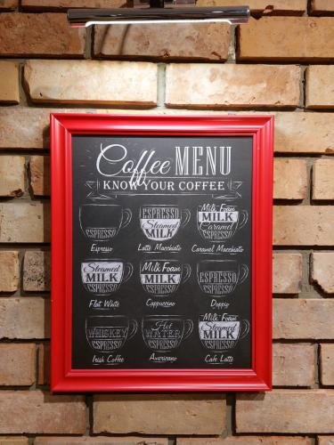 a chalkboard with a coffee menu on a brick wall at Coffee House in Gorzów Wielkopolski